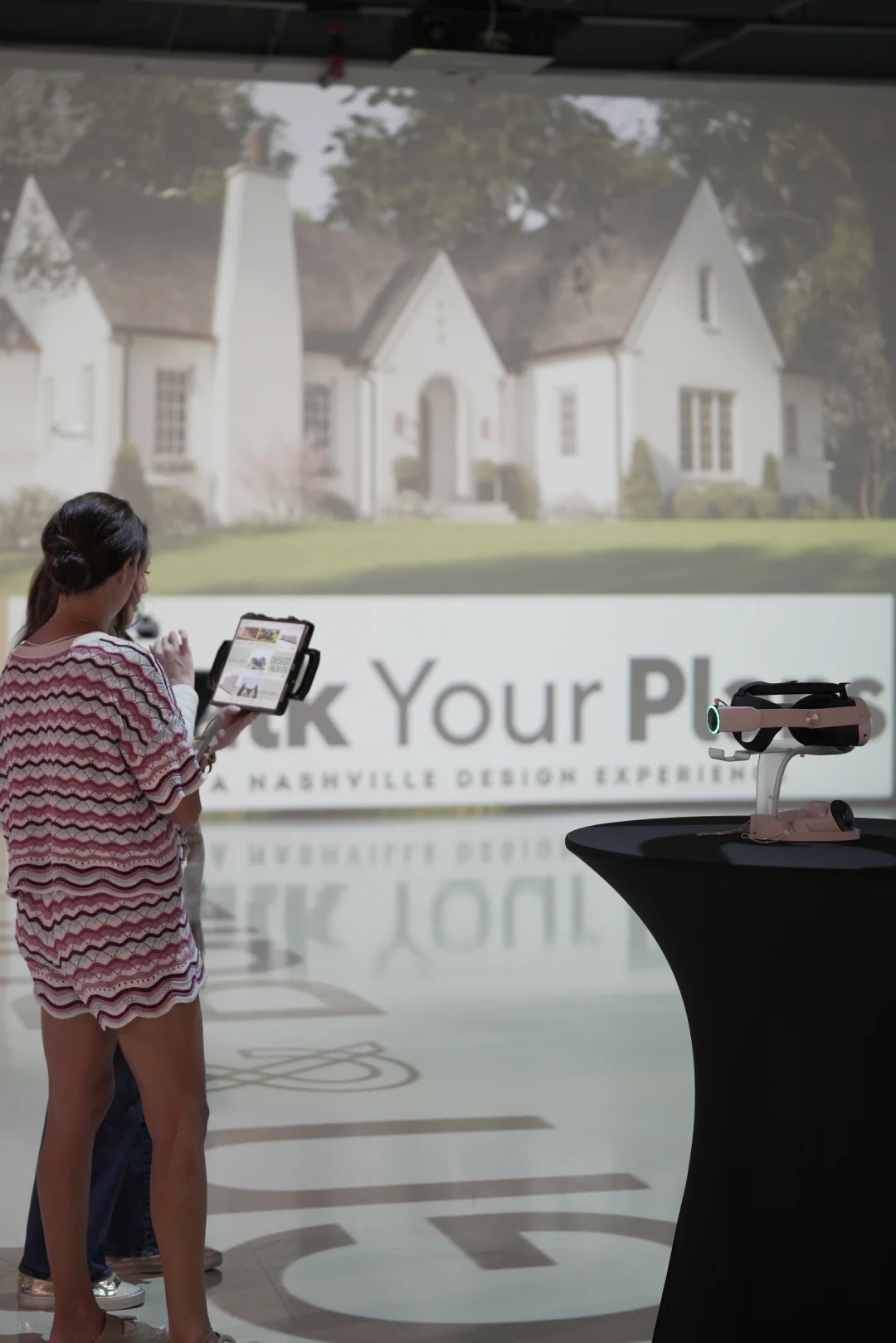 Woman using a tablet to view an augmented reality rendering of a home exterior in the Walk Your Plans studio