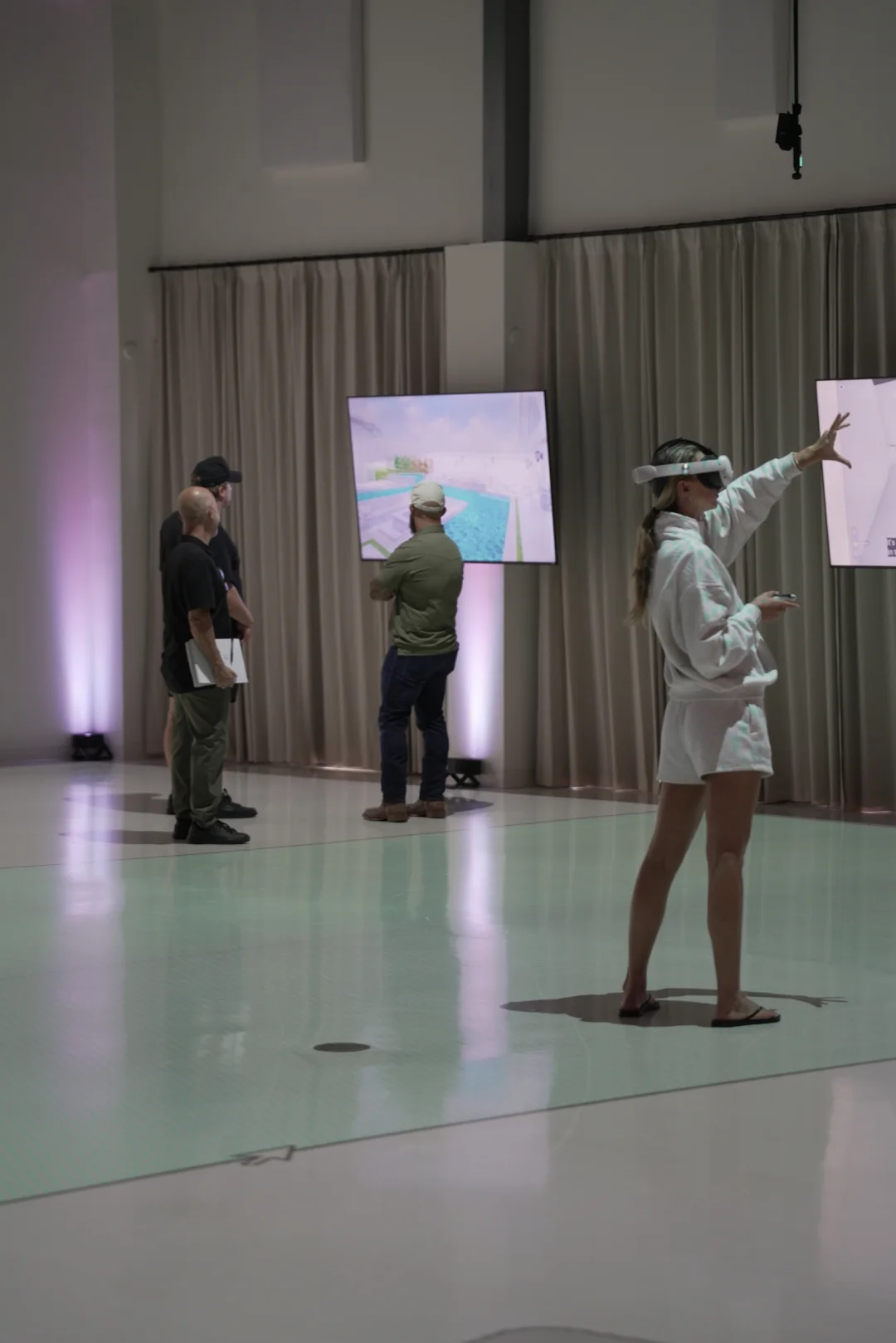 Woman using a VR headset to explore an interactive 3D model of a pool and backyard design