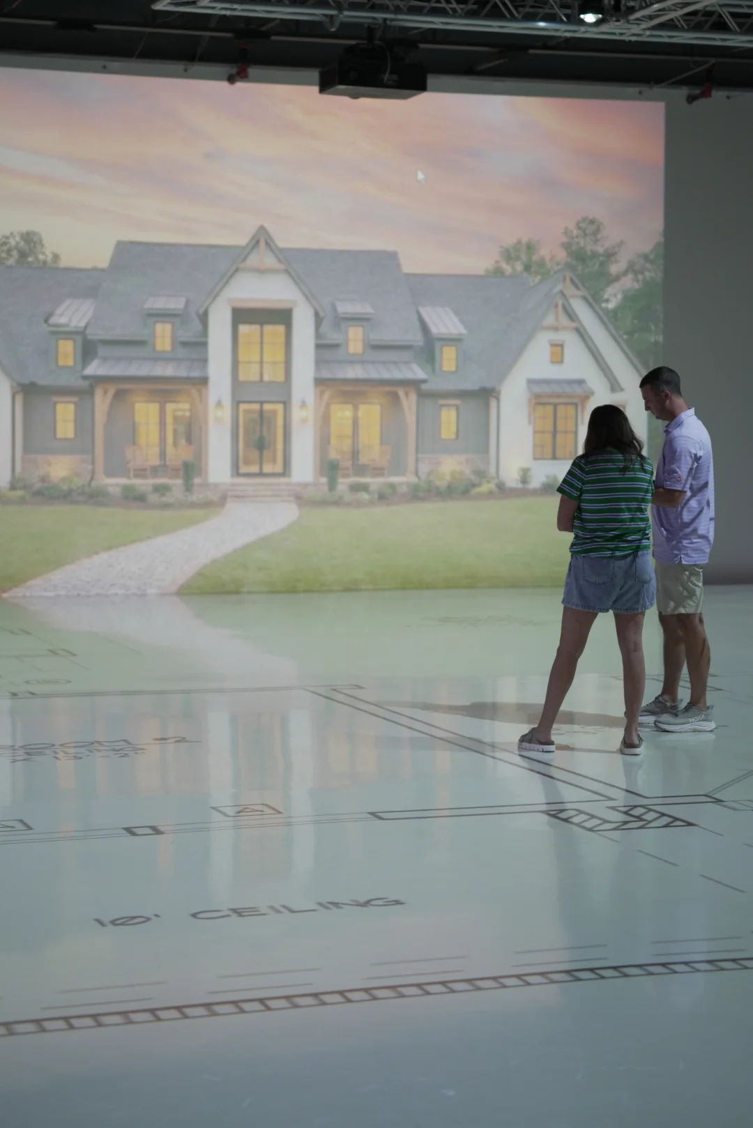 Couple viewing a life size rendering of a new home exterior before it is built