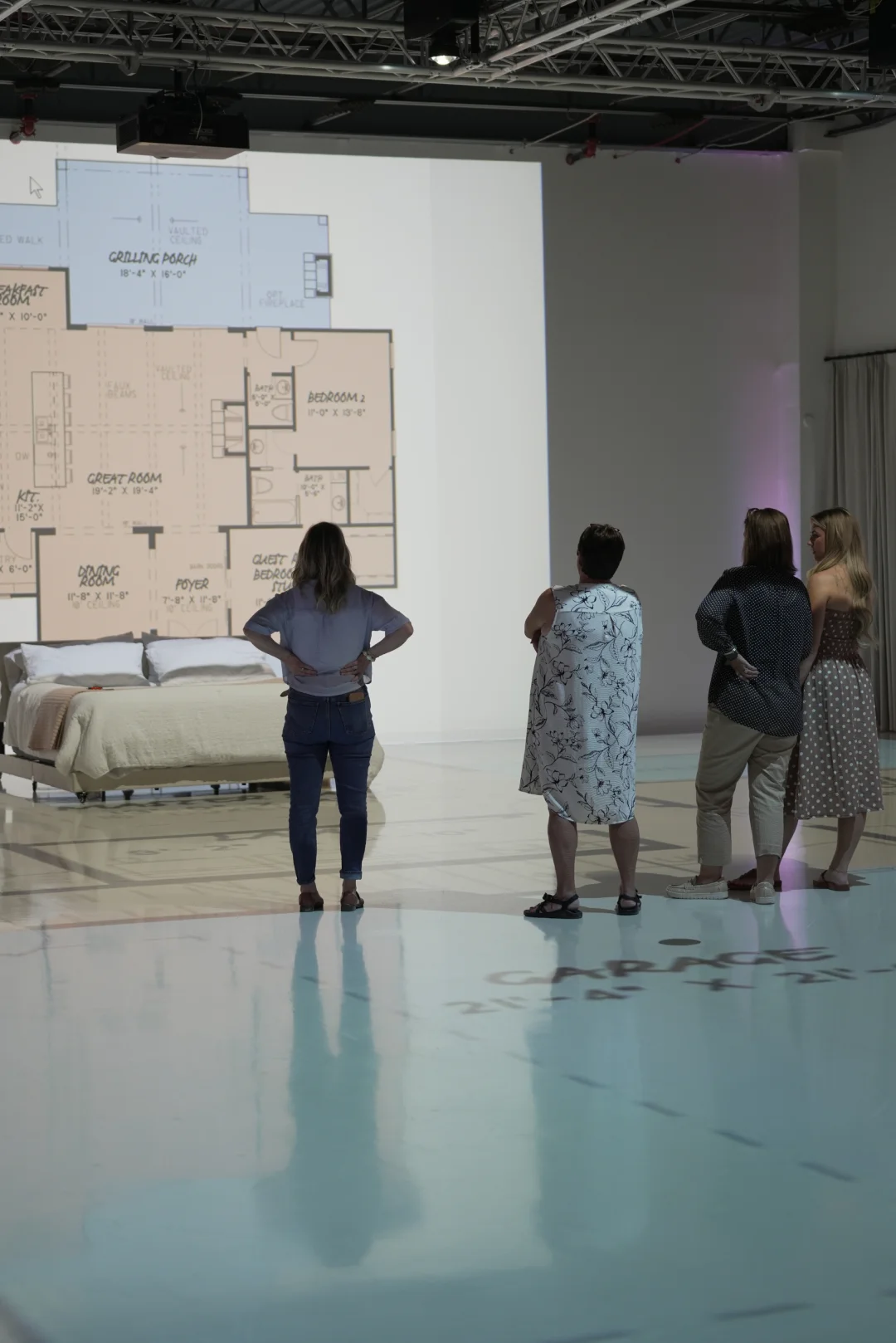Women reviewing a color floor plan and bedroom layout in the visualization studio
