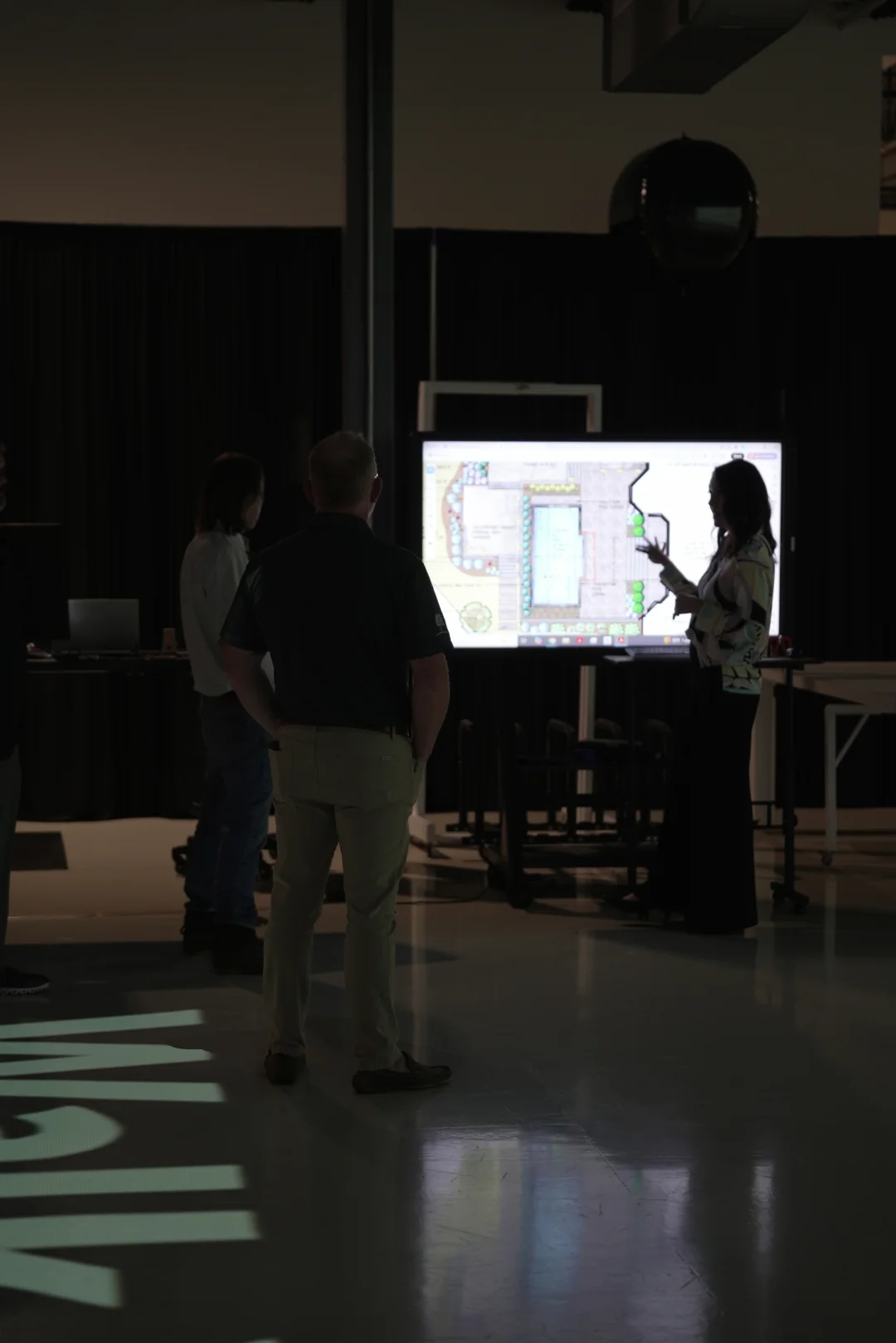 Walk Your Plans team member reviewing project options with clients on a digital plan display