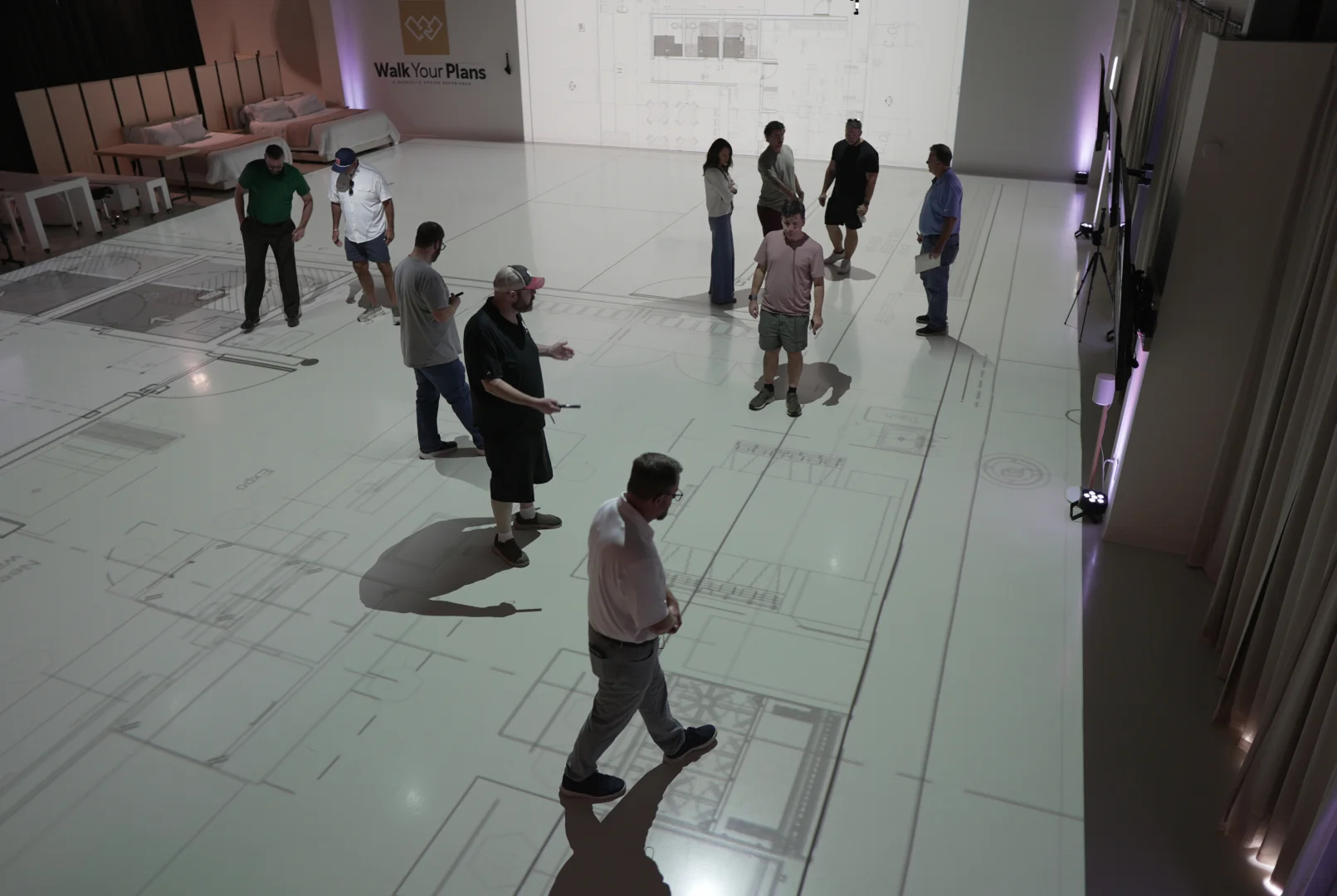 Group walking through a full-scale projected floor plan during a Walk Your Plans Nashville session