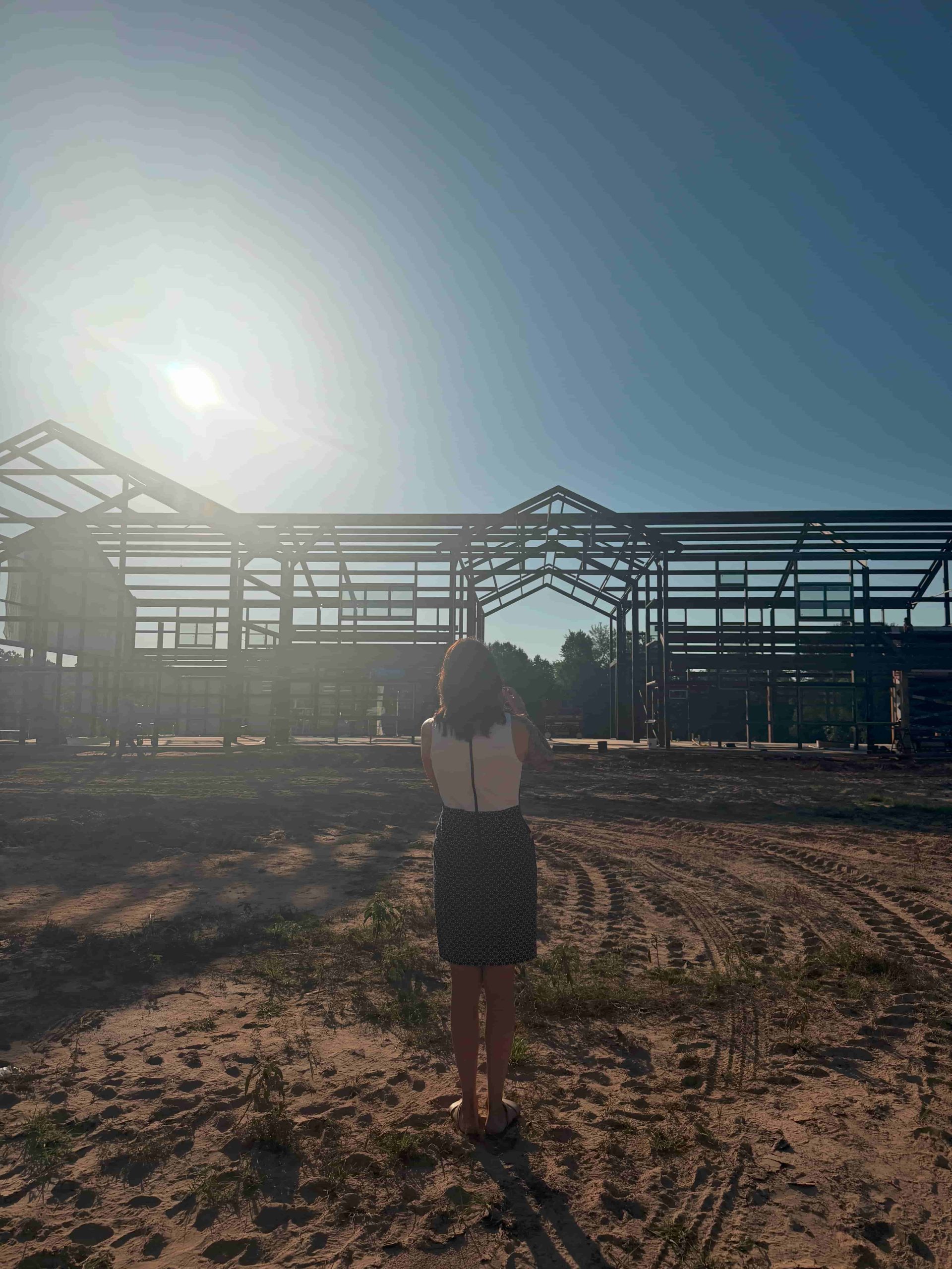 Steel Page Photo(1) Woman standing in front of a steel frame building under construction