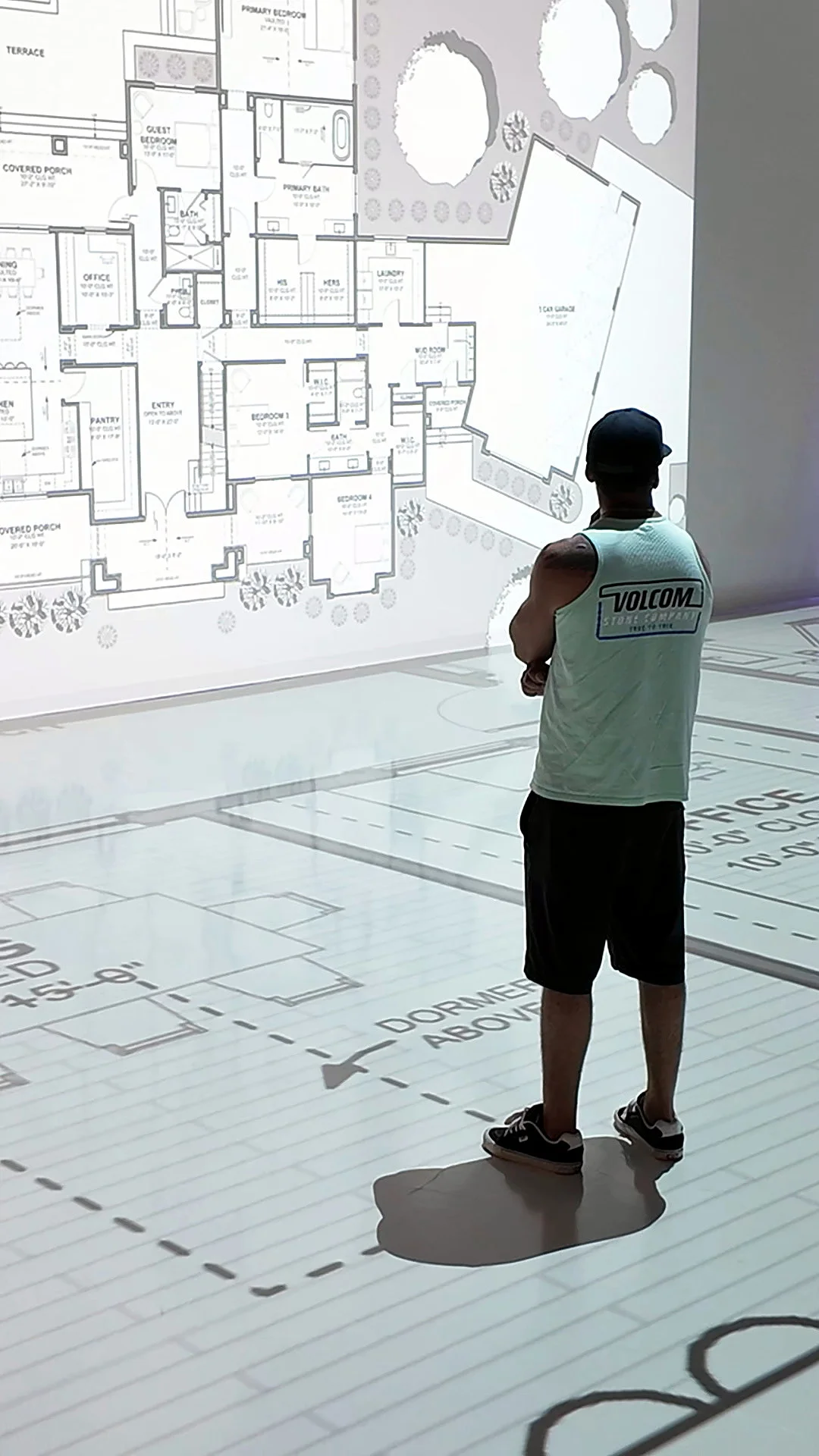 Homeowner standing in the great room of a life size floor plan projection