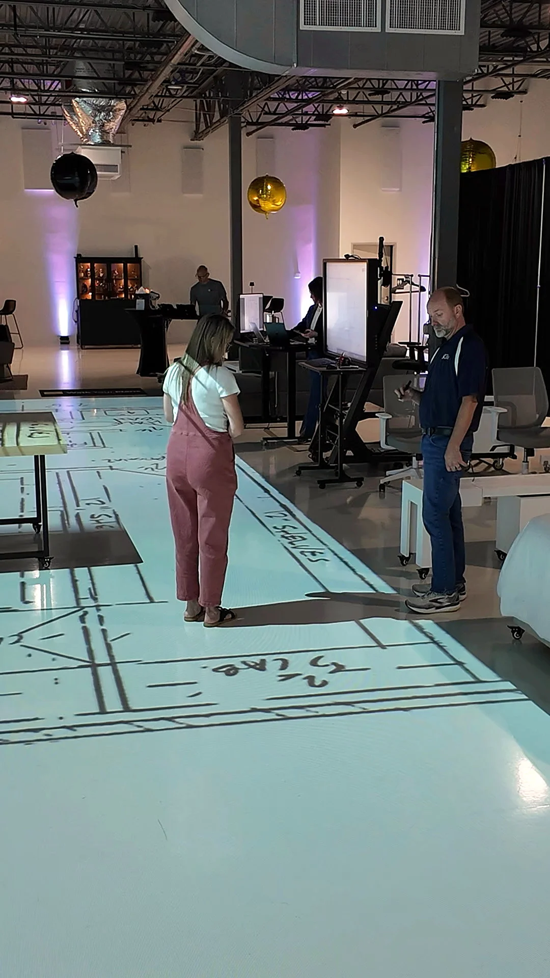 Visitor walking a projected floor plan in the Walk Your Plans Nashville studio
